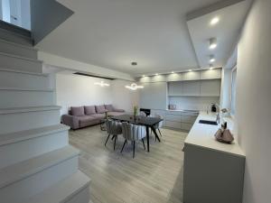 a kitchen and living room with a table and a couch at Apartament LuxLook in Nowy Sącz