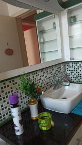 een badkamermeubel met een wastafel en een spiegel bij Condomínio Sol de Verao in Florianópolis +31 foto's