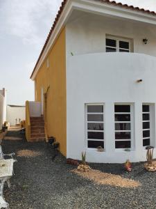 une maison blanche avec une terrasse couverte et un escalier dans l'établissement Home Favorito, à Tarajalejo