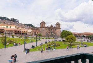 a group of people walking in a plaza in front of a building at Hostal Chasky in Cusco