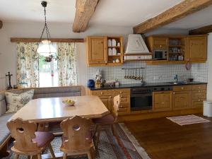 a kitchen with a wooden table and a table and chairs at Ferienhaus Holzinger in Rangersdorf