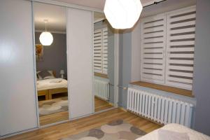 a room with a hallway with a mirror and a bedroom at Apartament Grapa in Żywiec