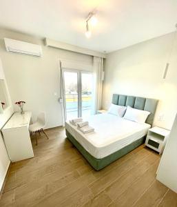 1 dormitorio con 1 cama grande y balcón en Eternal Suites Edessa, en Édessa