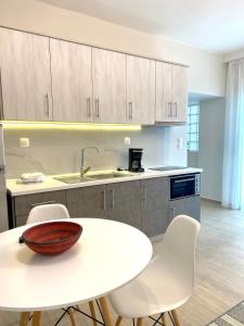 cocina con mesa blanca y sillas blancas en Eternal Suites Edessa, en Édessa