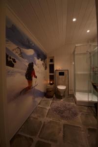 ein Badezimmer mit einem Bild eines Surfers an der Wand in der Unterkunft Kjosen Lodge, Lyngen. in Lyngseidet