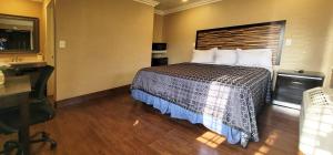 Cette chambre comprend un lit avec un bureau et un ordinateur. dans l'établissement RUBY MOTEL, à Long Beach