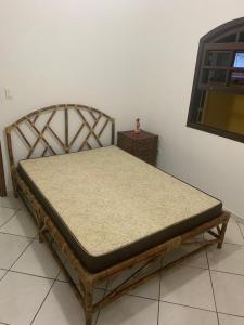 - un lit dans une pièce à côté d'un mur dans l'établissement Casa térrea em Caraguatatuba, à Caraguatatuba