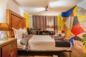 a hotel room with a bed and a colorful wall at Experience México City Condesa, Central Location, Rooftop Terrace, Coworking, Amazing Artistic Place in Mexico City