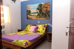 Schlafzimmer mit einem Bett mit Wandgemälde in der Unterkunft Le Mas Provençal - Appartements in Jaunde