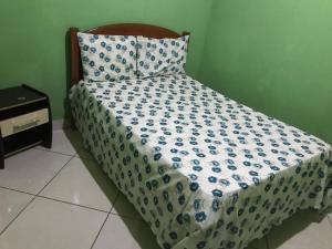 a bed with a blue and white comforter on it at Casa Laranja in Vale do Capao