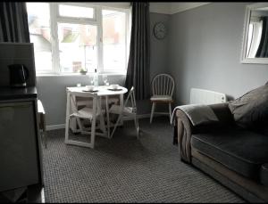 a living room with a table and a couch at 50 New Esplanade Court in Paignton