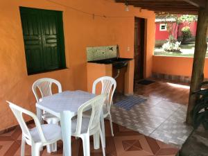 Un patio con mesa y sillas y una puerta verde. en Casa Laranja, en Vale do Capao