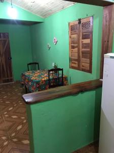 a room with a bed and a green wall at Casa Laranja in Vale do Capao