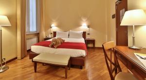 a dog laying on a bed in a hotel room at Best Western Hotel Metropoli in Genoa