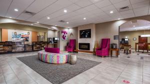 une salle d'attente avec des chaises roses et un canapé dans l'établissement Best Western Cannon A.F.B., à Clovis