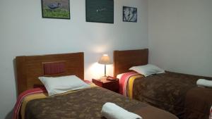 a hotel room with two beds and a lamp at Qoricancha B&B Cusco in Cusco +32 photos