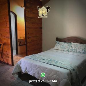 Un dormitorio con una cama y un baño con lavabo. en POUSADA HARAS K&k, en Pinhalzinho 5 fotos más