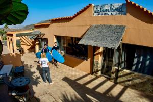 a group of people standing outside of a building with surfboards at Wellenkind Surfschool in La Pared