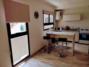 a kitchen with a table and some chairs in it at Condominio Plaza Italia - Cochera gratis in Mar del Plata