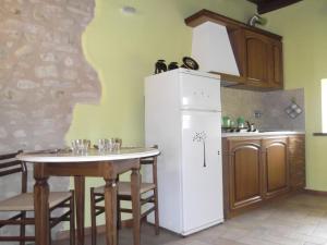 a kitchen with a table and a white refrigerator at A Casa Di Mì Appartamenti vacanza in Montefalco