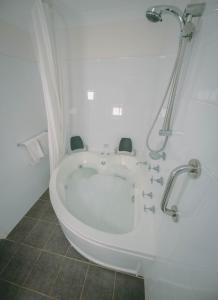 a bath tub in a bathroom with a shower at Darwin Resort in Darwin