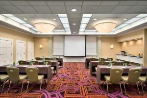 a conference room with tables and chairs and a whiteboard at Crowne Plaza Englewood, an IHG Hotel in Englewood