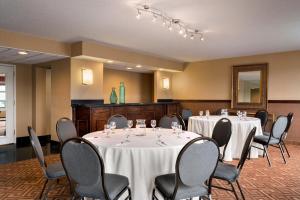 a conference room with tables and chairs and a mirror at Crowne Plaza Englewood, an IHG Hotel in Englewood