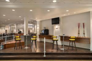 a lobby with a bar with yellow stools at Crowne Plaza Englewood, an IHG Hotel in Englewood