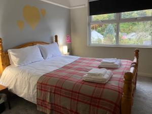 1 dormitorio con 1 cama con 2 toallas en Aeronfa, en Llanfairfechan