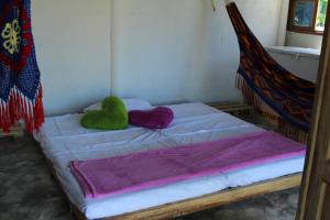DibullaにあるYaharo Posada Turísticaのベッド(緑と紫の枕2つ付)