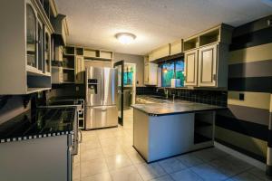uma cozinha com um frigorífico de aço inoxidável e armários em Country Living in the City. em Campbell River