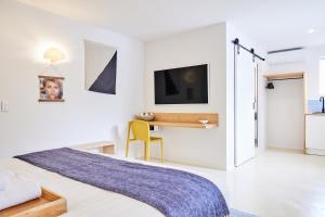 a bedroom with a bed and a desk and a tv at The Blue Water, Dreamtime Beach in Kingscliff