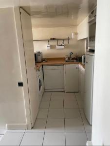 a small white kitchen with a washer and dryer at L'AUTHENTIQUE - Sur le Port - Parking - Wifi in Cassis