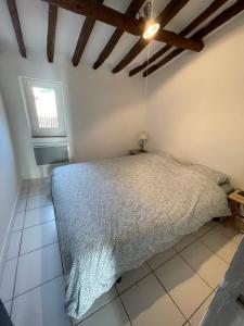 um quarto com uma cama num quarto com uma janela em L'AUTHENTIQUE - Sur le Port - Parking - Wifi em Cassis