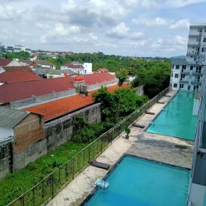 uma vista a partir da varanda de um edifício com duas piscinas em Vin's Room at Vivo Apartemen em Seturan