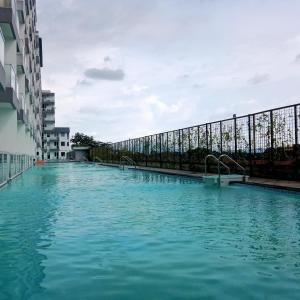 uma grande piscina de água azul ao lado de um edifício em Vin's Room at Vivo Apartemen em Seturan