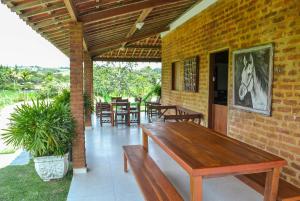 グラヴァターにあるChácara Maluco Beleza 4のパティオ(木製テーブル、いくつかの椅子付)