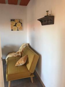 un sofá amarillo con una almohada en una habitación en Lavandas del Mar en Punta del Diablo