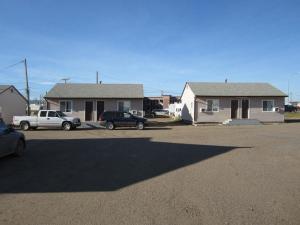 un coche aparcado en un estacionamiento junto a una casa en Midtown Motel on Alaska Ave, en Dawson Creek