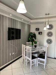 a dining room with a table and a tv on a wall at Apartamento Praia Central in Balneário Camboriú