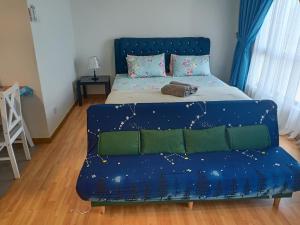 クアンタンにあるImperium Residence Tanjung Lumpur SEAVIEW Studio Hafizの青いソファ付きのベッド1台
