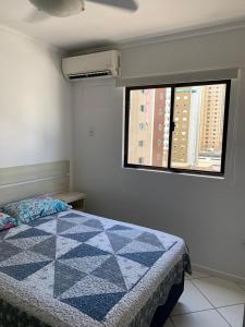 um quarto com uma cama e uma janela em Apartamento Praia Central no Balneário Camboriú