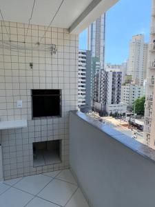 - une salle de bains carrelée de blanc avec vue sur la ville dans l'établissement Apartamento Praia Central, à Balneário Camboriú