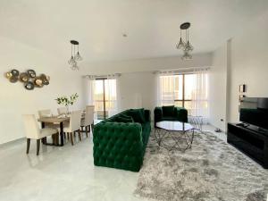 a living room with a green couch and a table at Luxury JBR Apartments , beach , pool , parking in Dubai