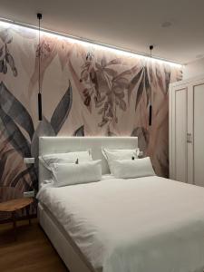 a bedroom with a large white bed with a floral wall at The Kepos Hotel Erlangen in Erlangen