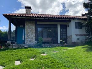 a small house with a bench in a yard at Acogedora cabaña de madera en la naturaleza para desconectarse in Sogamoso +4 photos