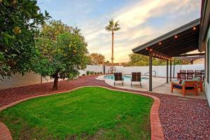 a backyard with a lawn and a swimming pool at ESTRELLA - Renovated with PATIO, BBQ, POOL & SPA in Chandler
