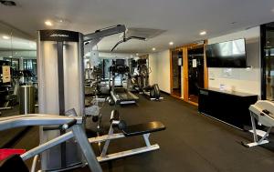 une salle de sport avec plusieurs tapis de course et une télévision dans l'établissement Extraordinary holiday stay for Melbourne explore, à Melbourne