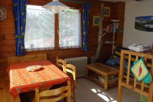 a dining room with a table and chairs in a cabin at Le Clos du Vas - Puy Saint André in Puy-Saint-André