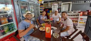 a group of men sitting around a table in a store at Pousada Parada Obrigatória Catimbau inn in Buíque
